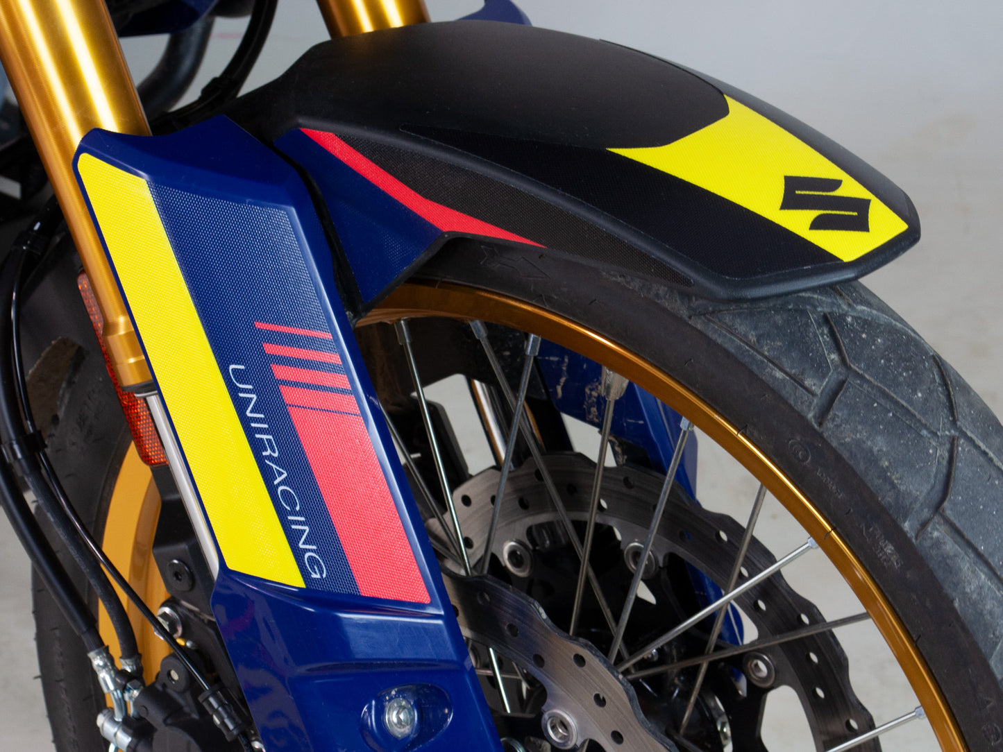 Foto detalle del kit de adhesivos de Uniracing para la Suzuki V-strom 800 en la parte del cubre horquilla.